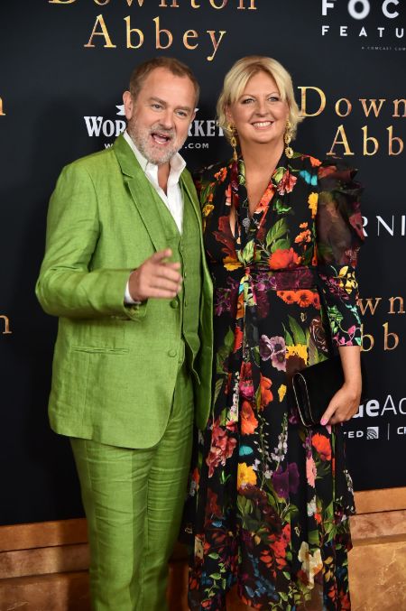 Hugh Bonneville in a green suit poses a picture with his wife Lucinda 'Lulu' Evans at the premier of Downtown Abbey.'